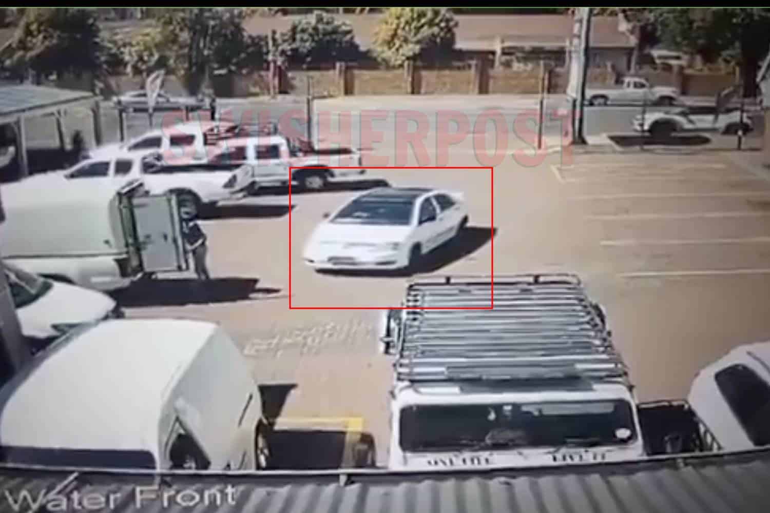 a white car pulling into a parking spot at a shopping centre